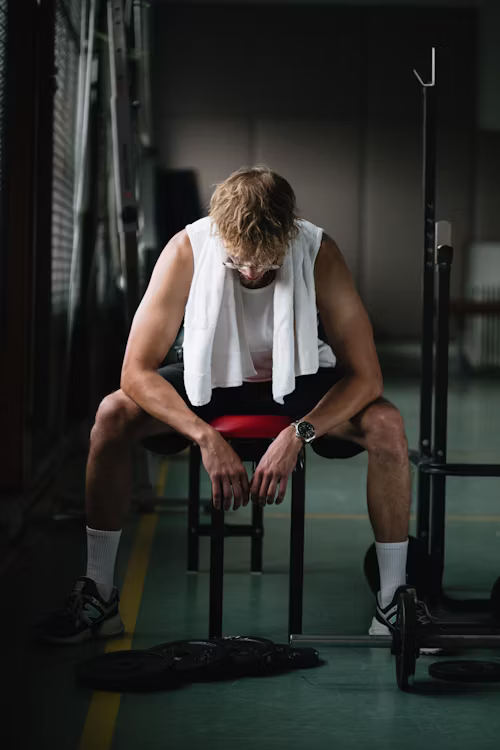 Member resting and breathing on a bench between sets